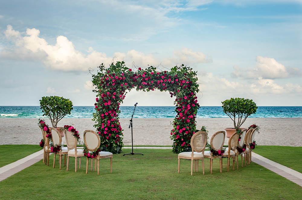 Flower arch and chairs set up for a beachfront Acqualina wedding