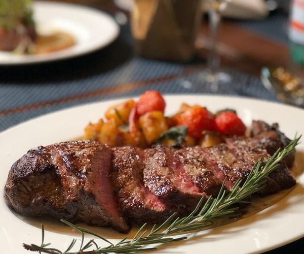 Grilled steak served with roasted vegetables and fresh rosemary