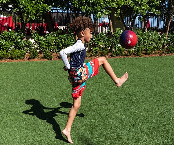 child playing soccer on grassy field