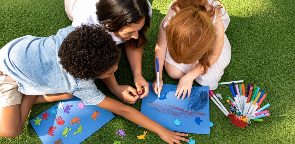 Kids coloring by the green lawn at Acqualina