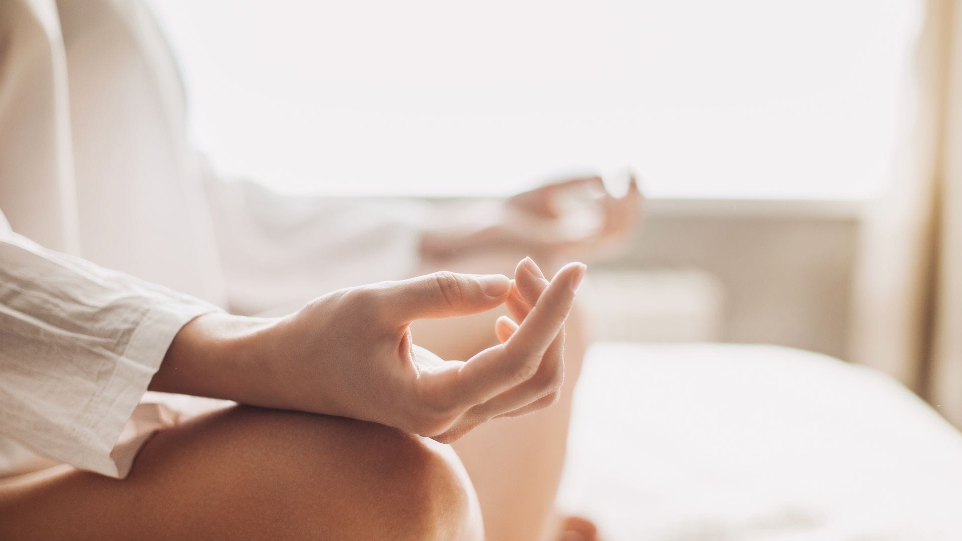 person meditating with hands in relaxed pose